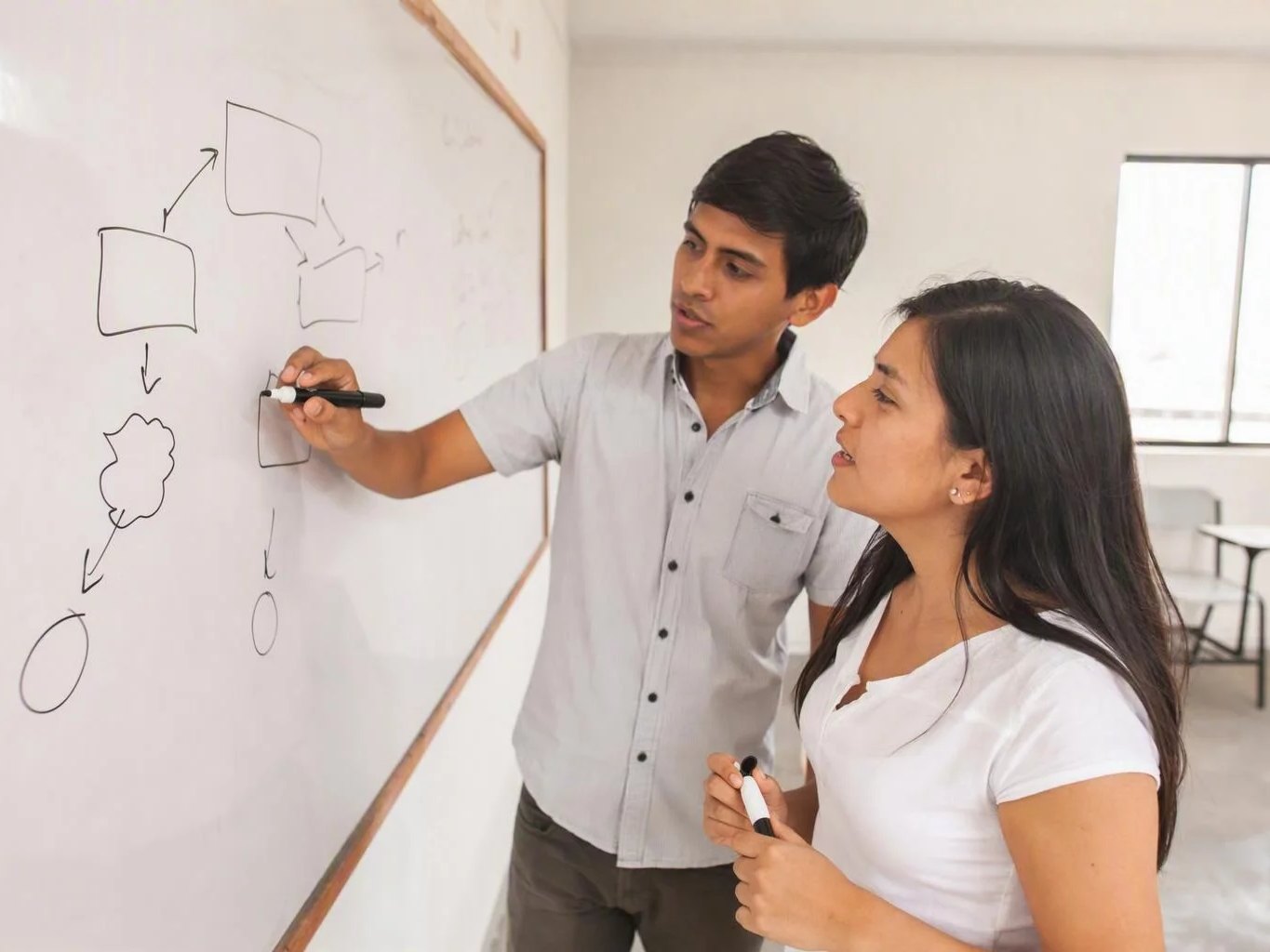Dos personas trazando en la pizarra la estructura de un argumento